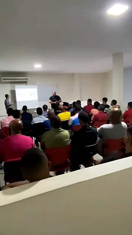 Participantes em sala acompanhando uma apresentação técnica com projeção.